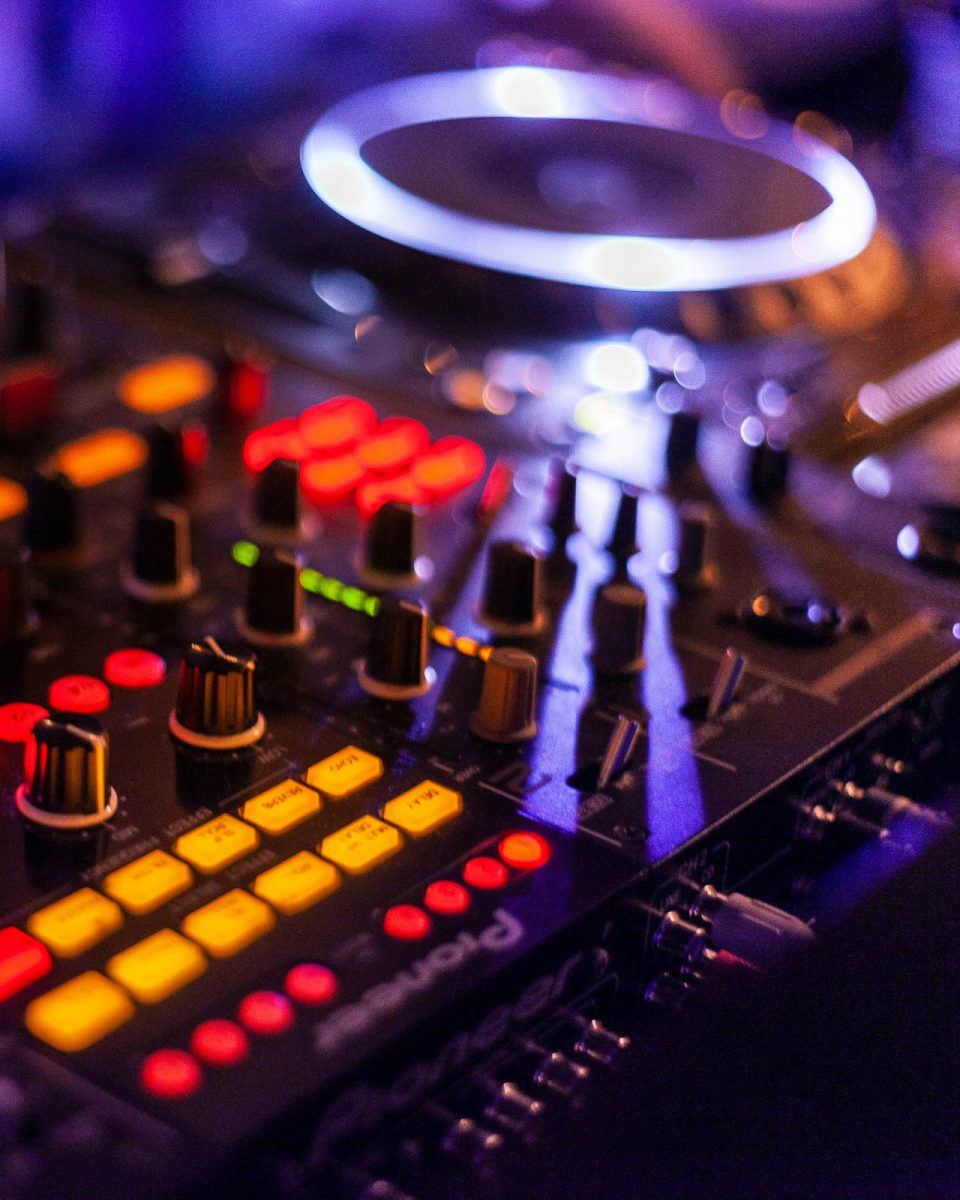 verschiedene Regler und leuchtende Knöpfe auf einem DJ Mischpult