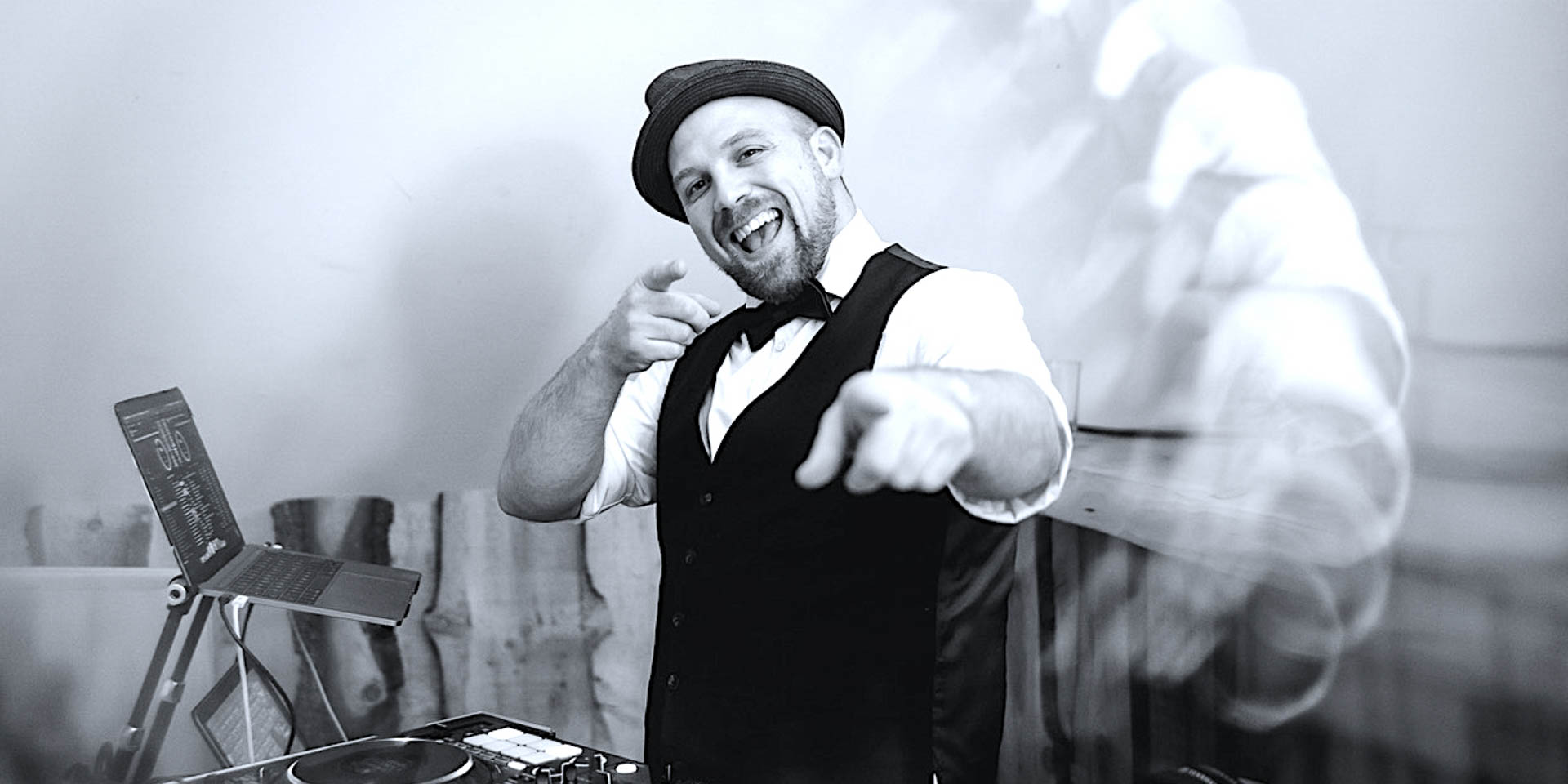 DJ Dominik feiert hinter seinem Mischpult während einer Party