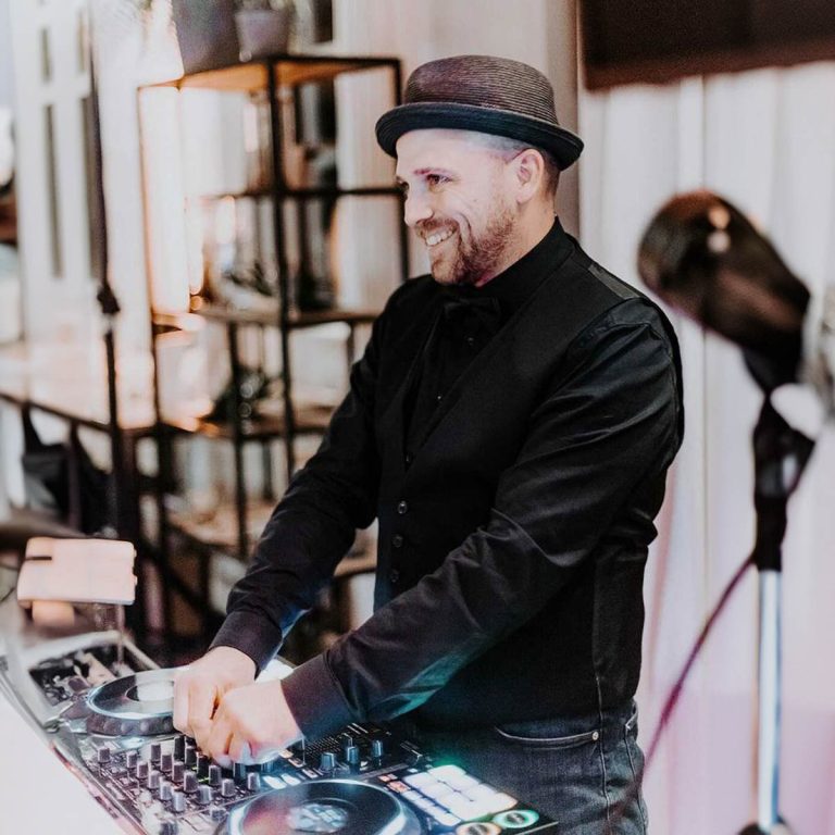 DJ Dominik bedient die Regler seines Mischpults während einer Veranstaltung