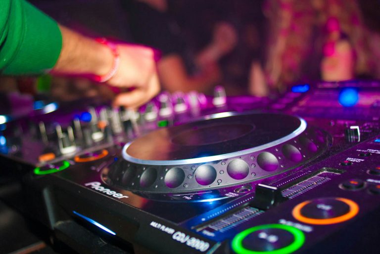 herangezoomter Pioneer DJ-Controller, an dem gerade ein DJ die Regler bedient
