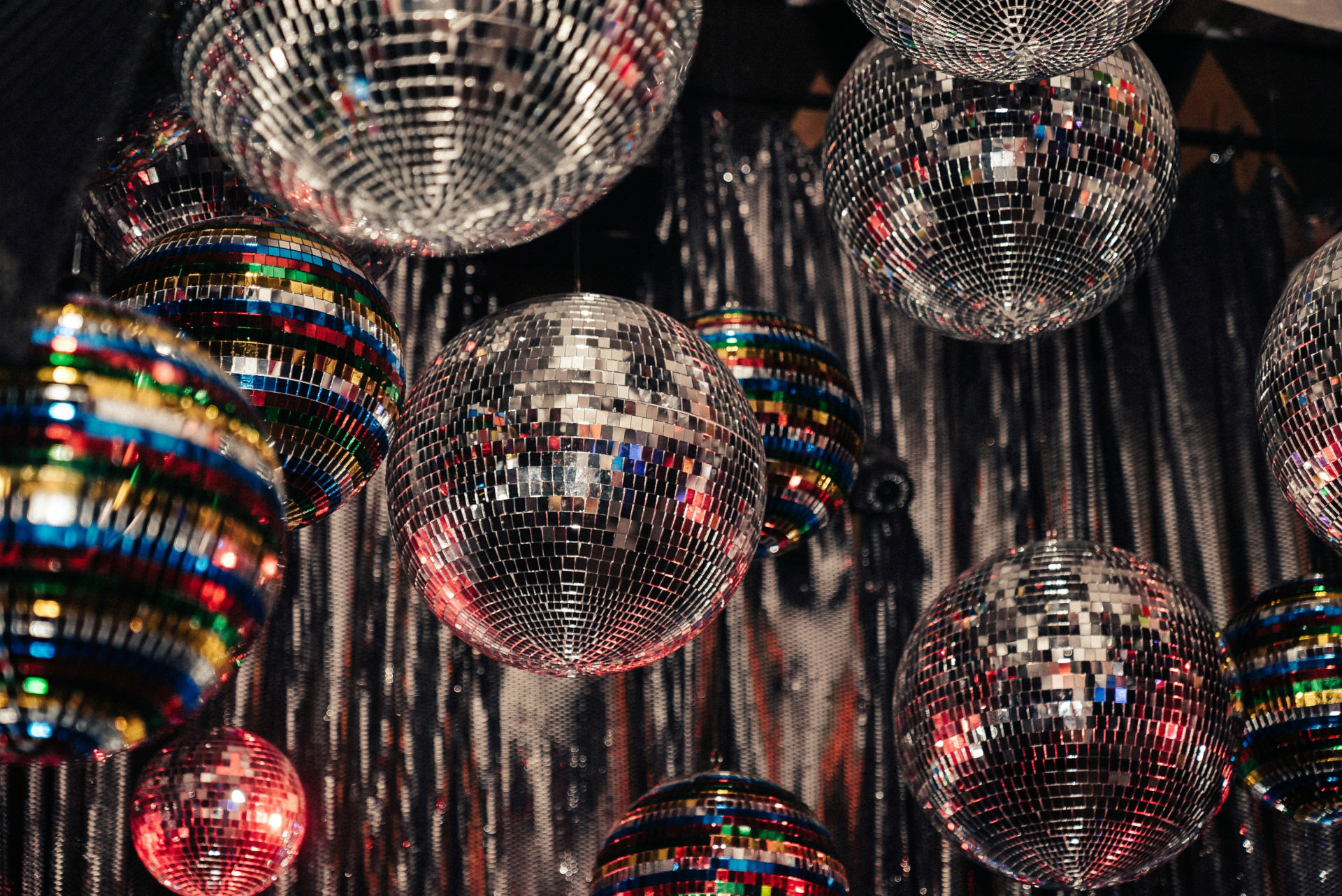 zahlreiche silberne Disco Kugeln hängen als Partydeko unter der Decke